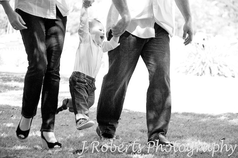 Little boy being swung by parents - family portrait photography sydney